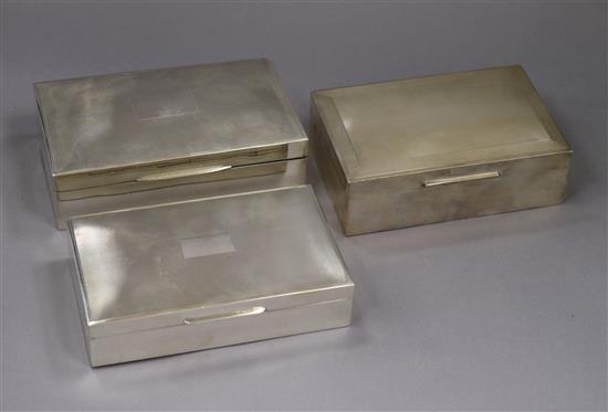Three assorted engine turned silver cigarette boxes, largest 15.4cm.
